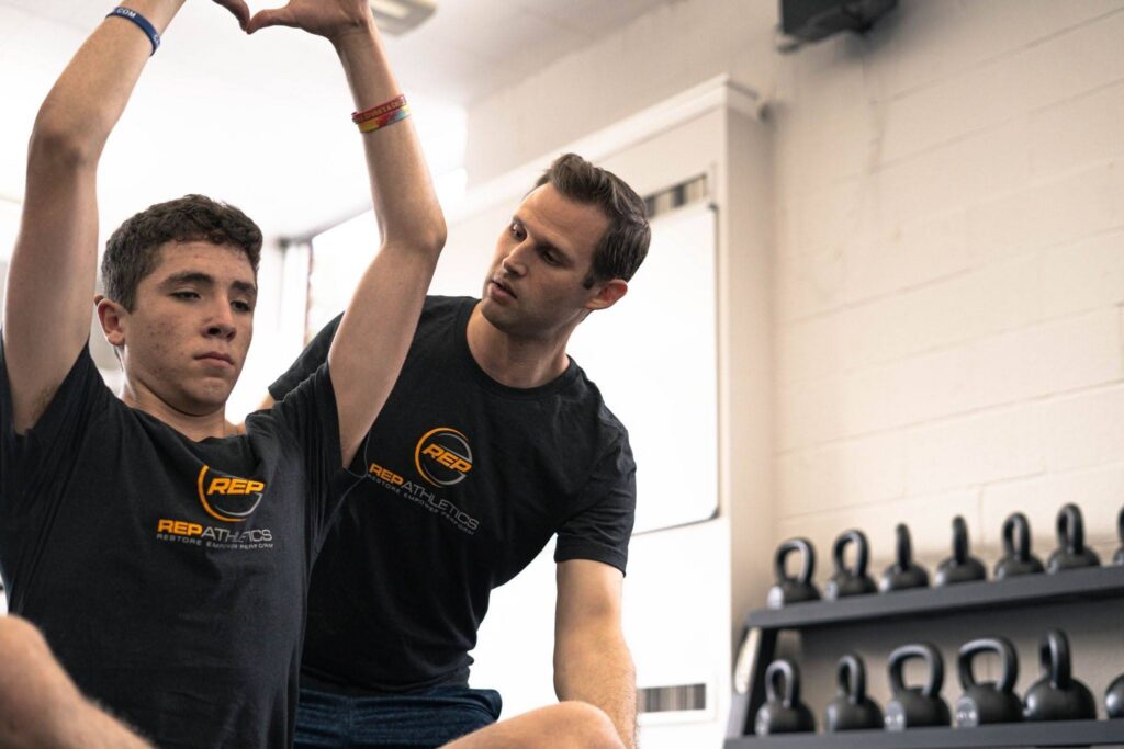Trainer guiding a client through back pain relief exercises in Westchester NY
